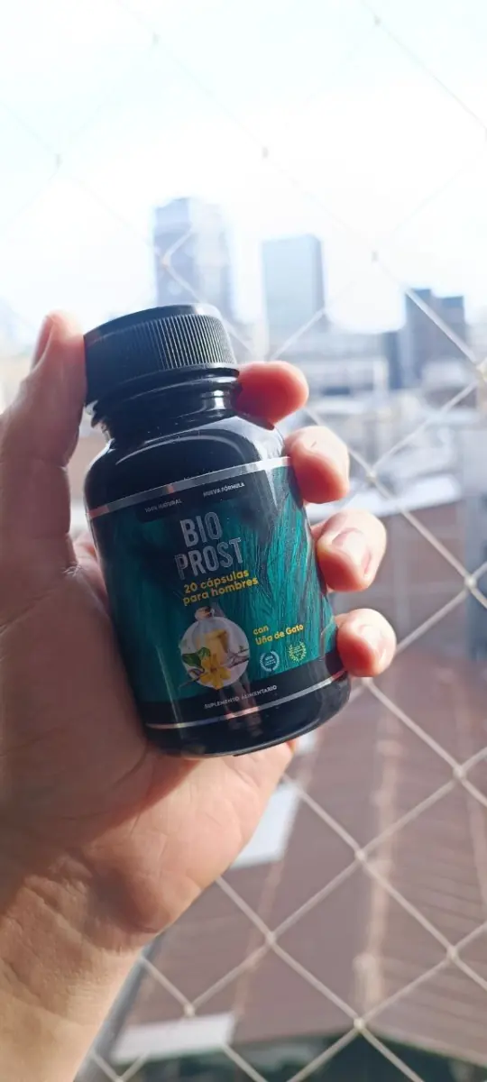 Frasco de Bio Prost en una mano frente a una ventana