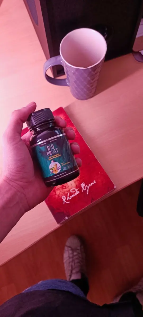 Frasco de Bio Prost en una mano sobre un escritorio